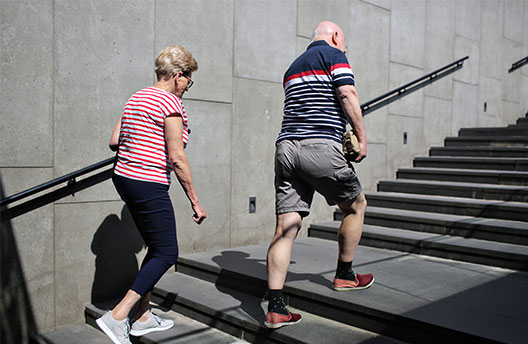 Starsza kobieta i starszy mężczyzna wchodzący na schody przejścia podziemnego
