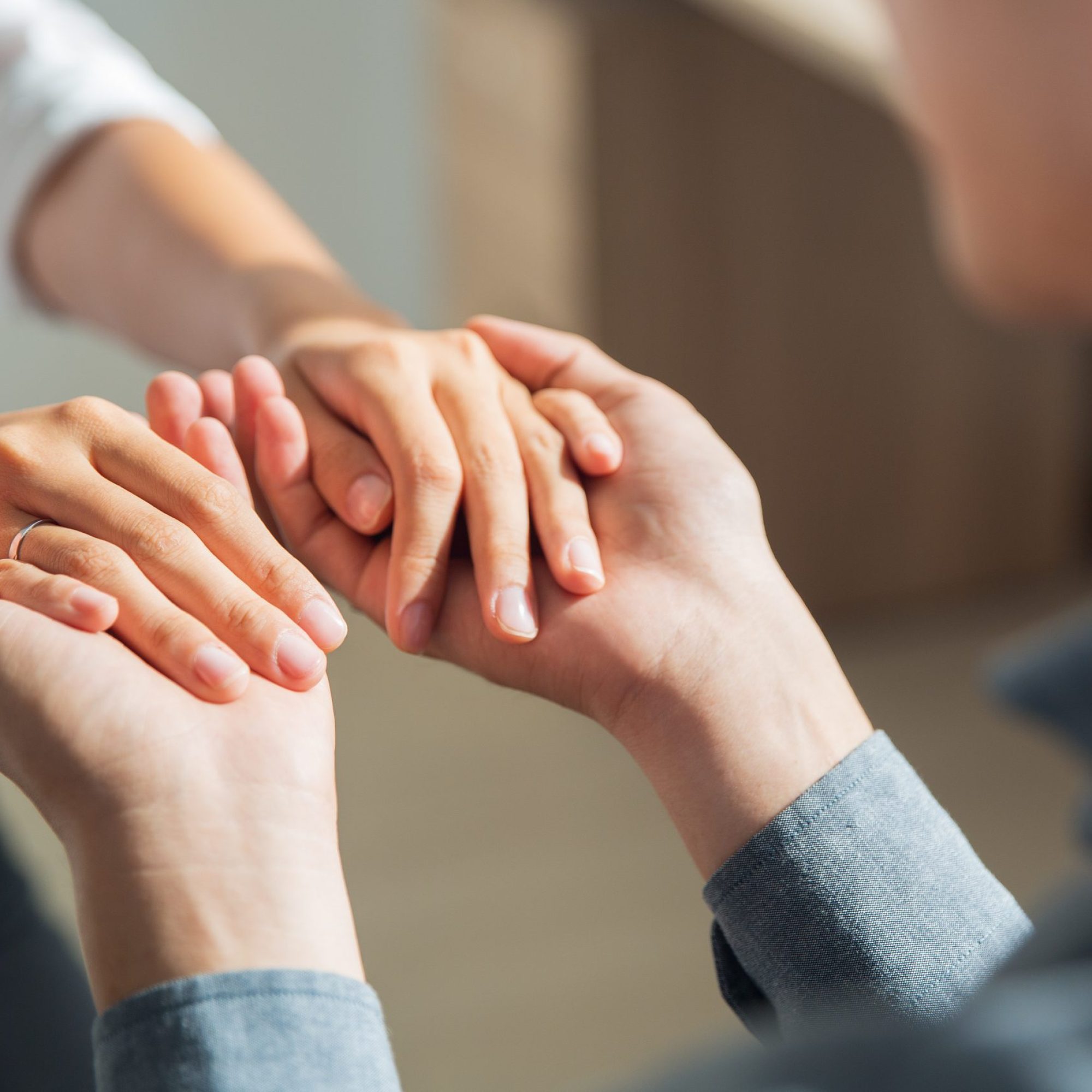 Young man holding hands of girlfriend Close-up of hands of young man holding hands of woman. Man proposing to his girlfriend indoors